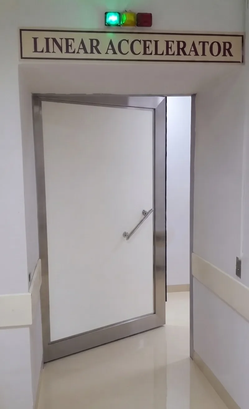 Hinged LINAC shielding door installed at a linear accelerator treatment room entrance with radiation warning lights
